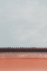 The roof of a home  on a minimalistic sky background.