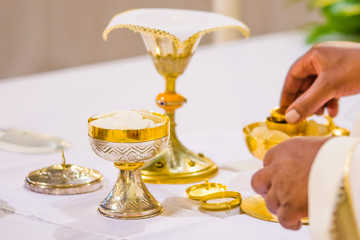 chalice with wine, blood of christ, and pyx with bread, body of christ, ready for the communion of...