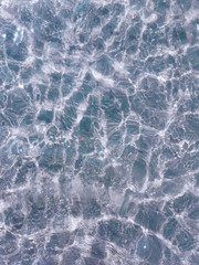 Hotel swimming pool with sunny reflections and waves