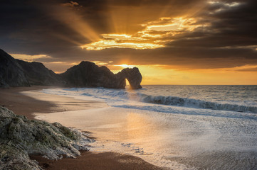 Majestic colorful sunrise over ocean landscape scene with cliffs and beautiful cloud formations