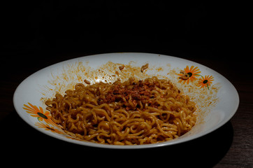 Indonesian fried instant noodles. fried noodles on a plate taken with low light. dark