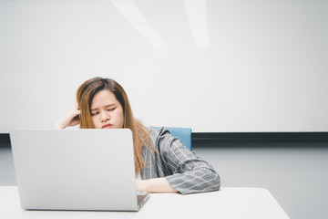 Woman working by laptop in office with thinking