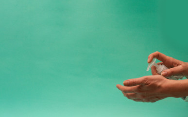 Woman sanitizing hands with antiseptic. Copy space