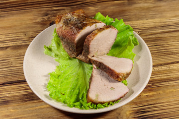 Tasty baked pork with spices on a wooden table