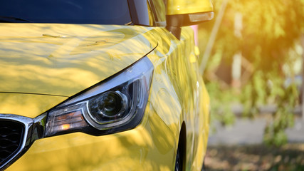 headlight of yellow modern car, image concept of summer road trip travel