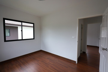 interior design empty room with white wall and wooden laminate floor in new residential house