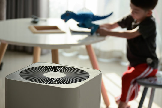 air purifier in living room with kid playing inside home