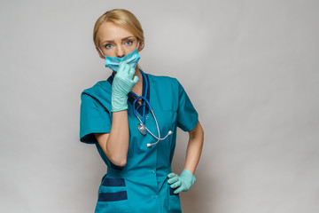 medical doctor nurse woman wearing protective mask and rubber or latex gloves - tired and stressed