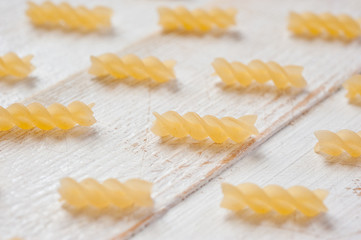 Obraz na płótnie Canvas Spiral pasta on a white wooden background. Background for cooking and food.