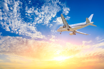 Commercial airplane flying in beautiful sky at sunset,travel concept.