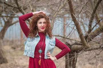 Fashionable woman in jeans vest and marsala dress , stylish woman outfit