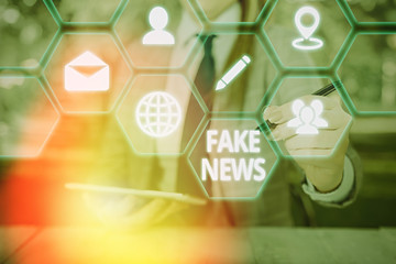 Conceptual hand writing showing Fake News. Concept meaning false information publish under the...