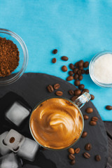 Dalgona Coffee Iced, Korean trendy fluffy creamy whipped black instant coffee blue background