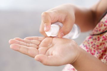 hand of child or people and kid girl holding and press alcohol gel in clear bottle pump for sterilize or kill disease covid-19 corona virus and anti dirt bacteria with clean or wash hands for hygiene