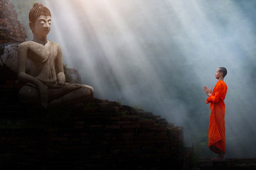 The monks stand to pay respect to the Buddha image.