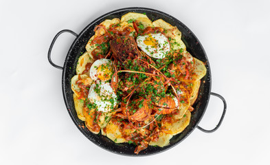 Formentera Lobster with fried potatoes, eggs and parsley in a traditional paella pan. Caldereta de bogavante de Formentera