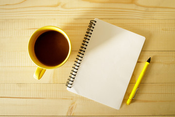 cup of hot chocolate on wooden background with notebook.  Work from home concept.