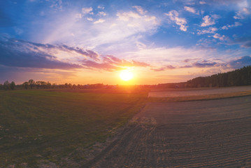 Spring rural landscape in the evening with beautiful sky, aerial view. Panoramic view of village and lake during sunset. Panorama from 9 images