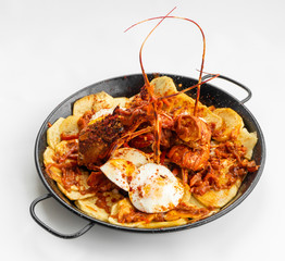 Formentera Lobster with fried potatoes, eggs and parsley in a traditional paella pan. Caldereta de bogavante de Formentera