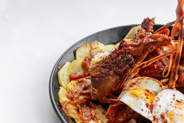 Formentera Lobster with fried potatoes, eggs and parsley in a traditional paella pan. Caldereta de bogavante de Formentera