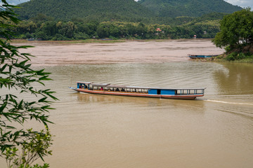 A slow boat at the confluence of ​the Mekong River and Nam Khan River, Luang Prabang, Laos.