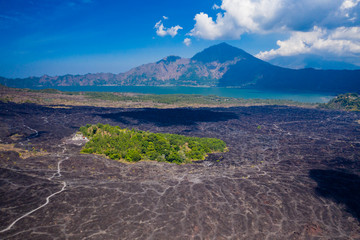 Aerial view of a black volcanic landscape consisting of old lava flows and channels.  Mount Batur, Bali, Indonesia