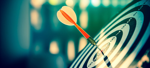 Bullseye(bull's-eye) or dart board has dart arrow hitting the center of a shooting target for business targeting and and  marketing goal concetps.
