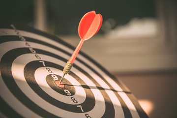 Bullseye(bull's-eye) or dart board has dart arrow hitting the center of a shooting target for...