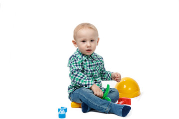 Cute baby plays with tools on a white background