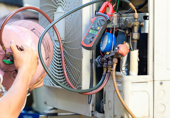 Air Conditioning Repair man checking and fixing modern air conditioning system, Technician team checking leakage air conditioning system