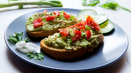 Avocado bruschetta with cherry tomatoes and cucumber