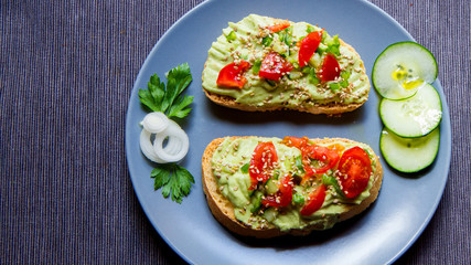 Avocado bruschetta with cherry tomatoes and cucumber