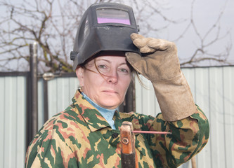 Portrait of a female welder in work clothes. - 340530605