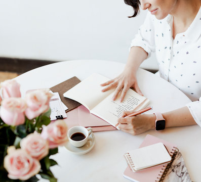 Positive woman writing on a notebook