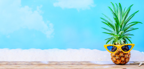 Pineapple with sunglasses on wood background. Creative minimal summer holiday concept