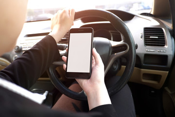 Cropped shot view of young businesswoman using laptop and smart phone  in a car.
