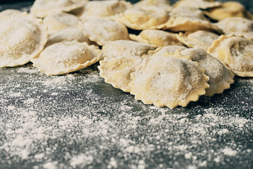 Tasty raw italian floured ravioli on wooden.