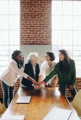 Diverse businesswomen hands together