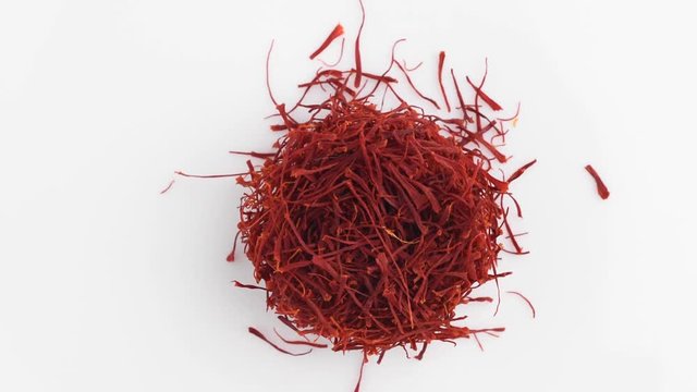 Heap of saffron threads, autumn crocus, on turntable isolated on white background