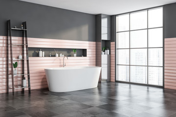 Gray and pink bathroom corner with tub and shelf