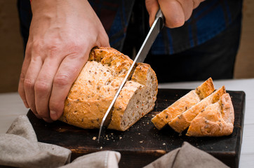 Homemade pastries. Men's hands cut homemade blush bread