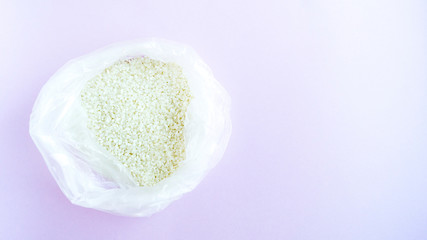  White rice in a bag on a light background. 
