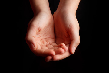 Fototapeta premium Children's open palms are on a black background.