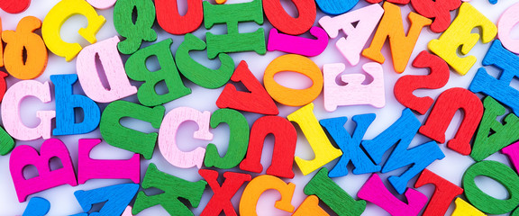 Letters of the alphabet are randomly scattered on a white background.