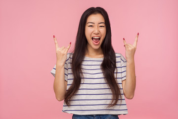 Portrait of delighted crazy girl with long hair in striped t-shirt showing rock and roll punk...