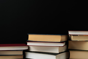 Stacks of books several on a black background close-up. Back to school, education, learning,