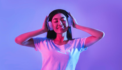 Girl listen to music in modern headphones