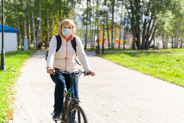 A woman on a Bicycle rides on the road in the city Park