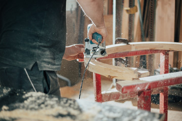Joinery, woodworking and furniture making, professional carpenter cutting wood in carpentry shop,...