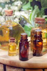 Assortment of natural oils in glass bottles on wooden background. Concept of pure organic ingredients in cosmetology. Bath accessoiries, atmosphere of harmony, relax. Close up macro. Healthy lifestyle